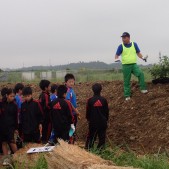 少年たちに植樹指導する植樹リーダー