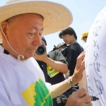 参加者のTシャツにメッセージを書く宮脇昭博士 宮城県岩沼市千年希望の丘植樹祭2013